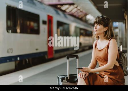 Frau, die im Bahnhof von Antwerpen sitzt Stockfoto