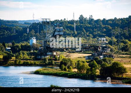 Verlassene Bergbaumaschine neben einem See Stockfoto