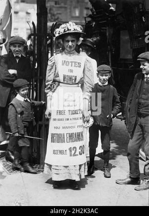 Suffragetten. Vera Wentworth (geb. Jessie Alice Spink; 1890-1957), die mit einer Schürze am Strand, London, entlang läuft, um für einen märz 1909 zu werben. Stockfoto