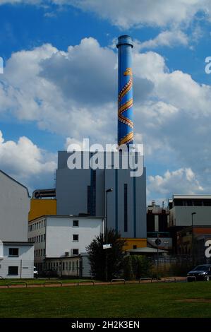 FRANKFURT, DEUTSCHLAND - 10. Jul 2021: Blick auf die Müllverbrennungsanlage Heddernheim, Frankfurt, Deutschland. Kamin vor einem wunderschönen blau-weißen Su Stockfoto