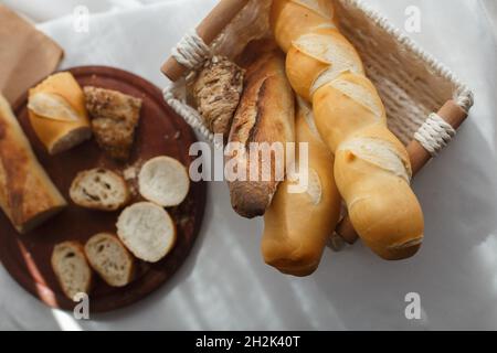 Roggen, Weizen und Mehrkornbaguettes in einem Weidenkorb, Draufsicht Stockfoto
