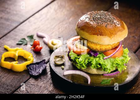 Vegetarischer Burger, ist ein fleischloses Sandwich aus Mais, Kartoffeln, texturiertem Sojaprotein, Hülsenfrüchten, Tofu, Pilze, Müsli Stockfoto