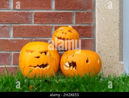 Geschnitzte drei halloween Kürbisse, Dekoration und Feiertagskonzept, geschnitzte Kürbisse für eine lustige Party, lustige und wütende Gesichter, Jack o's Laterne, halloween t Stockfoto