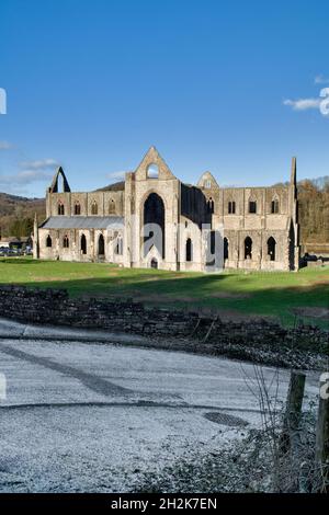 Tintern Abbey im Wye Valley in Monmouthshire, großbritannien an einem sonnigen Wintertag mit Frost im schattigen Bereich und blauem Himmel dahinter Stockfoto