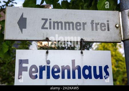 Das deutsche Zeichen Zimmer frei und Ferienhaus übersetzt in freie Stellen und Ferienhaus in englischer Sprache Stockfoto