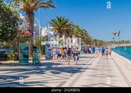 LAGOS, PORTUGAL - 6. OKTOBER 2017: Menschen gehen auf einer Uferpromenade in Lagos, Portugal. Stockfoto