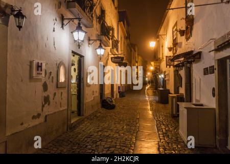 OBIDOS, PORTUGAL - 11. OKTOBER 2017: Nachtansicht einer engen gepflasterten Straße im Dorf Obidos, Portugal Stockfoto