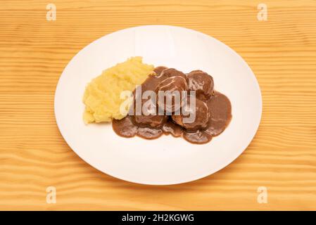 Köstliche Fleischbällchen in Sauce mit hausgemachten Kartoffelpüree auf weißem Teller im spanischen Tapas-Restaurant Stockfoto