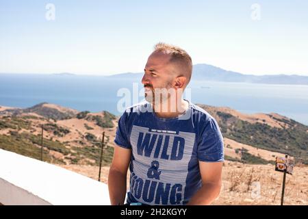 Aufnahme eines kaukasischen Mannes in einem blauen Hemd im Mirador del Estrecho in Tarifa, Cadiz, Andalusien, Spanien Stockfoto