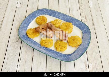 Pica Dominikanisches Huhn mit Patacon. Gebratene reife Banane und Huhn mit Bier, Gewürzen und schwarzem Pfeffer mariniert Stockfoto