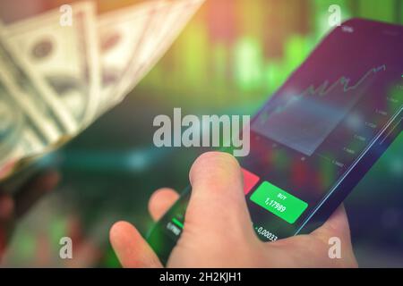 Smartphone mit Handy Investing Anwendung. Mobiles Börsen-Trading und Kryptowährungskonzept – Hintergrundfoto Stockfoto