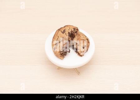 Frisch gebackene Plätzchen aus geschmolzener dunkler Schokolade und gesalzenem Karamell auf hellem Holztisch Stockfoto