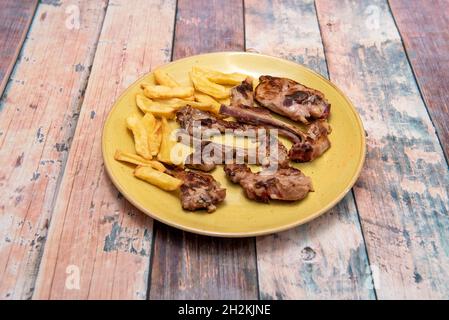 Beliebtes spanisches Rezept für gebratene Lammkoteletts mit hausgemachten Chips Stockfoto