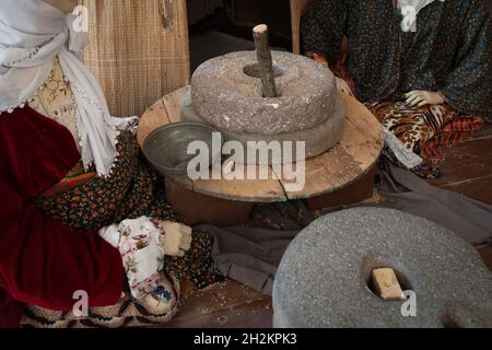 Eine alte Handmühle aus Steinen und Holz. Mehlschleifvorrichtung. Authentisches Kunsthandwerk Stockfoto