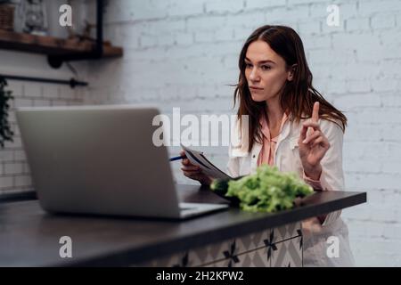 Der Arzt des Ernährungsberaters hält einen Online-Termin und warnt den Patienten. Stockfoto