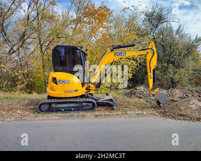 Moderner gelber JCB-Bagger oder Bagger führt Aushubarbeiten im Freien durch Stockfoto