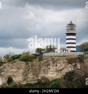 Blick auf den Leuchtturm an der Küste gegen bewölkten Himmel. Schöner Leuchtturm auf den Felsen bei Sile, Istanbul, Türkei, Schwarzes Meer. Quadratisches Bild Stockfoto