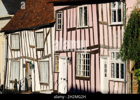 Eine Reihe von wundersamen, krummen alten Fachwerkhäusern kurz vor Sonnenuntergang in Lavenham, Suffolk, England Stockfoto