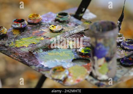 Bild mit geringer Schärfentiefe (selektiver Fokus) und einer Farbpalette für Maler, während an einem sonnigen Herbsttag eine Landschaft gemalt wird. Stockfoto