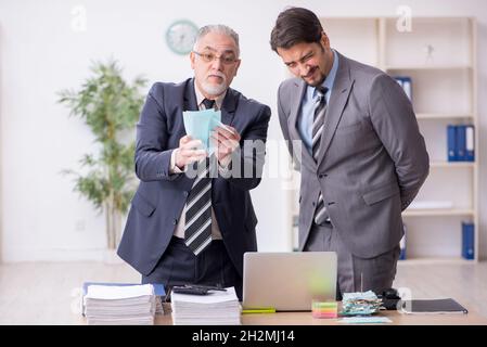 Zwei männliche Buchhalter im Budgetplanungskonzept am Arbeitsplatz Stockfoto
