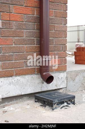 Nahaufnahme der installierten Regenrinne und des Abflusssystems. Das Regenrinnensystem wurde entwickelt, um Wasser vom Dach zu entfernen und die Abwärtsausgänge sind nach Di zu entfernen Stockfoto