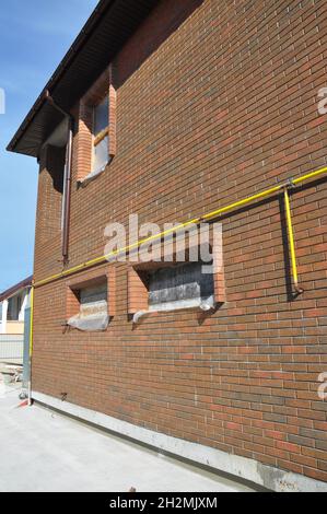 Nahaufnahme des in der Hauswand installierten Anschlusses für das Gasleitungssystem. Stellen Sie Gasleitungsanschlüsse von Stahl- oder Kupferrohren zu Bereichen, Wäschetrockner SAF her Stockfoto