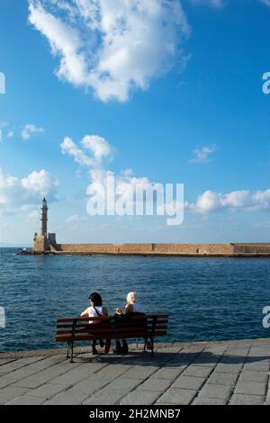 Chania, Kreta - Griechenland - Oktober 20 2021 : Historischer alter Leuchtturm am charmanten venezianischen Hafen dieser schönen Stadt Urlauber genießen die Aussicht Stockfoto