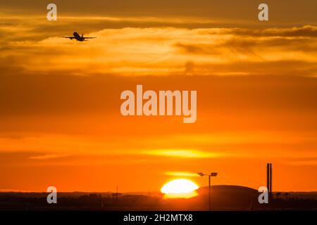 Flugzeug, das am späten Nachmittag vom Flughafen London Heathrow abfliegt, mit einem wunderschönen Sonnenuntergang im Hintergrund Stockfoto