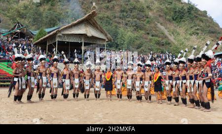 Naga-Tribesmänner und -Frauen, die am 2. Dezember 2016 beim Hornbill-Festival in Nagaland Indien in traditioneller Kleidung tanzten Stockfoto