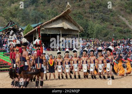 Naga-Tribesmänner und -Frauen, die am 2. Dezember 2016 beim Hornbill-Festival in Nagaland Indien in traditioneller Kleidung tanzten Stockfoto