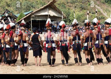 Naga-Tribesmänner und -Frauen, die am 2. Dezember 2016 beim Hornbill-Festival in Nagaland Indien in traditioneller Kleidung tanzten Stockfoto