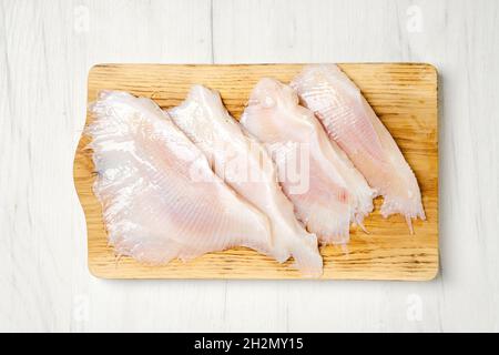 Blick von oben auf rohe, frisch geschälte, stingrau Flügel auf Holzschneidebrett Stockfoto