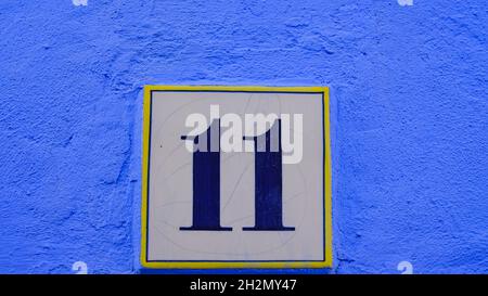 Keramik-Haus-Zahlentabelle. Nummer: 11 auf blauem Hintergrund Stockfoto