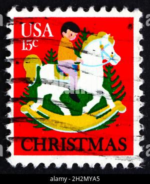 USA - UM 1978: Eine in den USA gedruckte Briefmarke zeigt das Kind auf Hobbypferden und Weihnachtsbäumen, um 1978 Stockfoto