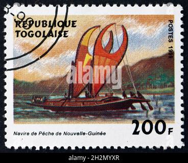 TOGO - UM 1999: Eine in Togo gedruckte Marke zeigt das Fischerboot Neuguineas, Segelschiff, um 1999 Stockfoto