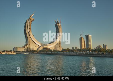 Lusail Corniche am Yachthafen in Lusail City, Katar, Sonnenuntergangsaufnahme mit Menschen, die auf der Promenade mit Skyline im Hintergrund spazieren gehen Stockfoto