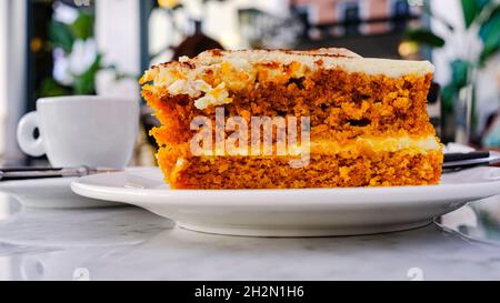 Seitendetail von Karotte und Sahnetorte mit einer Tasse Kaffee auf dem Boden Stockfoto
