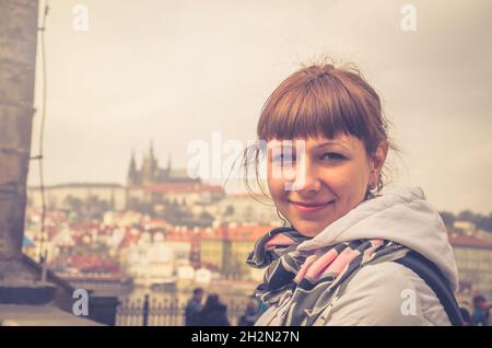 Nahaufnahme eines jungen Reisenden, der die Kamera anschaut und lächelt, der Prager Burg, der St.-Veits-Kathedrale im Hradcany-Viertel der Prager Stadtgeschichte Stockfoto