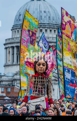 London, Großbritannien. 23 Okt 2021. Amal verlässt die St. Paul's Cathedral und überquert die Millennium Bridge - die kleine Amal, eine 3.5 Meter hohe Marionette eines jungen Flüchtlingsmädchen, ist auf einer Reise durch die Türkei und durch Europa unterwegs, um ihre Mutter zu finden. Der Spaziergang ist ein Wanderfestival der Kunst und Hoffnung zur Unterstützung von Flüchtlingen, mit der künstlerischen Leitung von Amir Nizar Zuabi und die Puppe wurde von der Handspring Puppet Company geschaffen. Als Vertreter aller vertriebenen Kinder, viele von ihren Familien getrennt, reist der kleine Amal über 8.000 km und verkörpert die dringende Botschaft „Vergiss uns nicht“. Kredit: Guy Bell/Alamy Live Ne Stockfoto