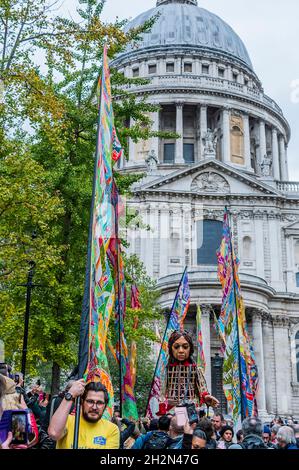 London, Großbritannien. 23 Okt 2021. Amal verlässt die St. Paul's Cathedral und überquert die Millennium Bridge - die kleine Amal, eine 3.5 Meter hohe Marionette eines jungen Flüchtlingsmädchen, ist auf einer Reise durch die Türkei und durch Europa unterwegs, um ihre Mutter zu finden. Der Spaziergang ist ein Wanderfestival der Kunst und Hoffnung zur Unterstützung von Flüchtlingen, mit der künstlerischen Leitung von Amir Nizar Zuabi und die Puppe wurde von der Handspring Puppet Company geschaffen. Als Vertreter aller vertriebenen Kinder, viele von ihren Familien getrennt, reist der kleine Amal über 8.000 km und verkörpert die dringende Botschaft „Vergiss uns nicht“. Kredit: Guy Bell/Alamy Live Ne Stockfoto