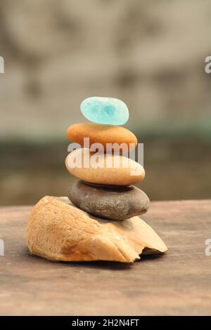 Verschiedene Arten von Steinkieseln und Seeglaswaagen auf einer Holzdiele Stockfoto