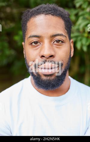 Kopf Und Schultern Porträt Eines Lächelnden Jungen Mannes, Der Im Garten Im Freien Steht Stockfoto