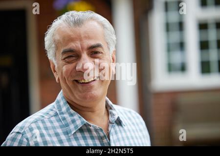 Portrait von reifer Mann im Garten Vor der Traumhaus auf dem Land Stockfoto
