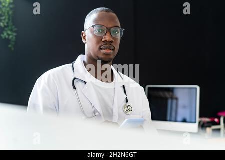 Männlicher Arzt mit Smartphone in der medizinischen Klinik Stockfoto