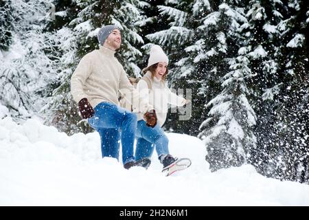 Paar umarmt, während sie im Winter im Wald stehen Stockfoto