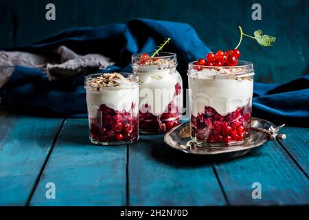 Joghurt-Parfait mit roten Johannisbeeren und Nüssen Stockfoto