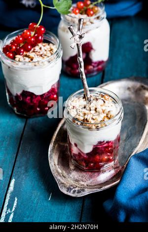 Joghurt-Parfait mit roten Johannisbeeren und Nüssen Stockfoto