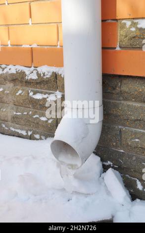 Gefrorener Regen Wasser Abflussrinne Abflussrohr. Rinne im Winter. Stockfoto