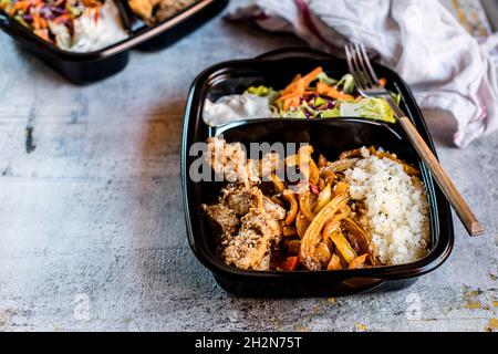 Verzehrfertige Fajita-Schüssel mit Huhn, Salat, gebratener Paprika und Blumenkohlereis Stockfoto