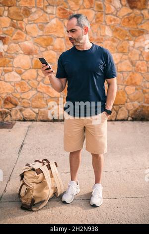 Reifer Mann mit Rucksack, der in der Gasse läuft Stockfoto